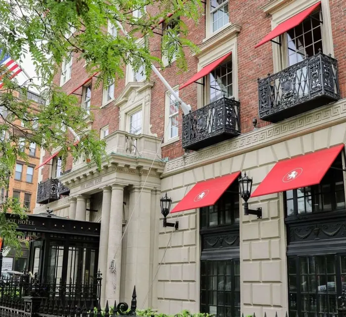 The Eliot Hotel facade with red awnings on Commonwealth Avenue via Expedia