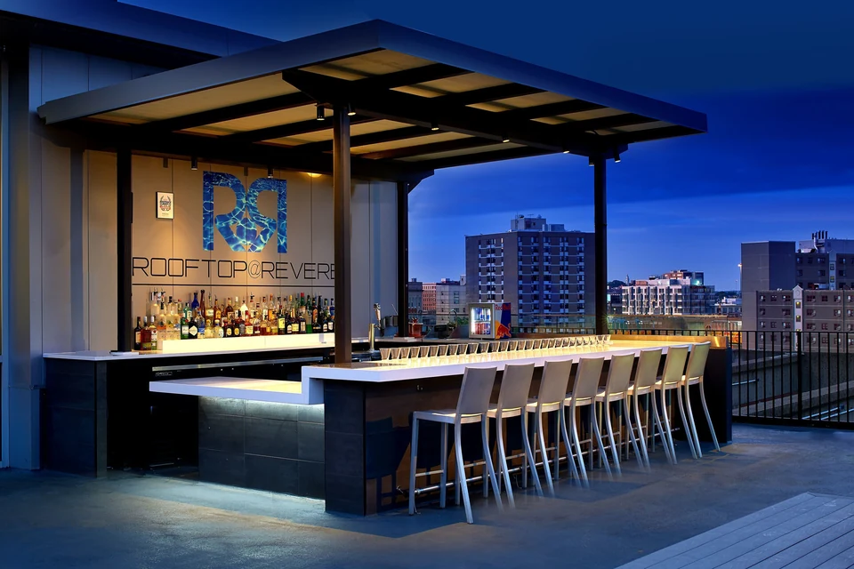 Revere Hotel Boston Common rooftop bar at night via Expedia