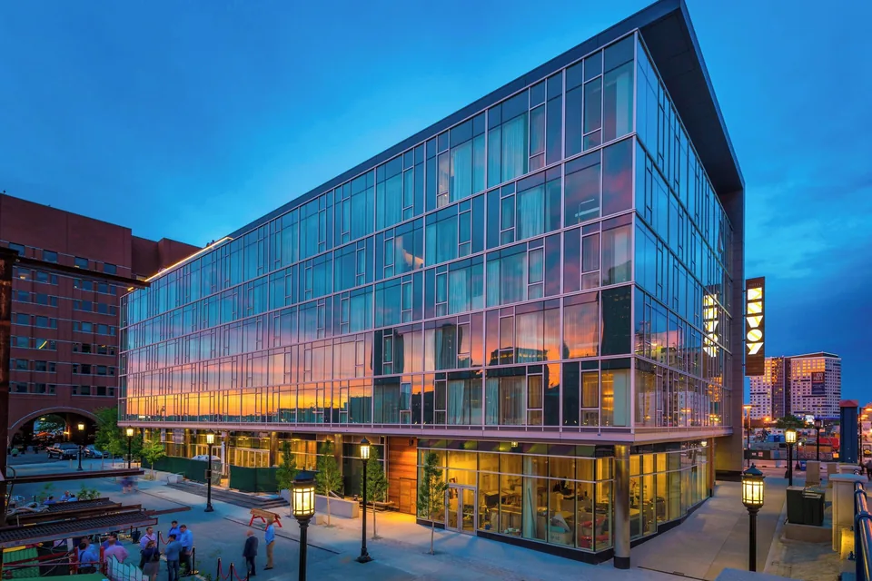 The Envoy Hotel glass building on Fort Point Channel at dusk via Expedia