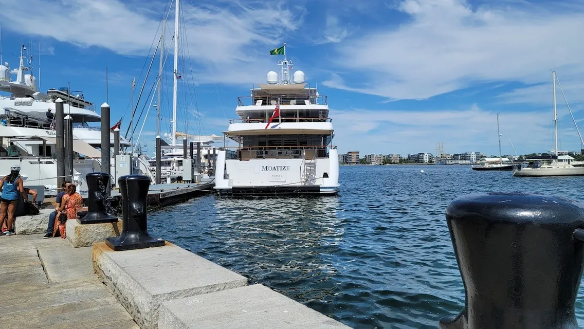 White yacht moored at a granite wharf on sunny Boston Harbor