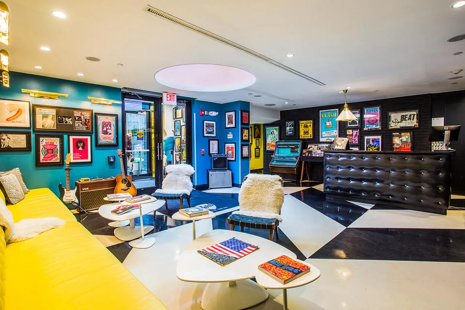 Music-themed hotel lobby with guitars, framed album art and yellow sofas