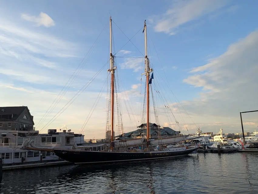 Tall-masted schooner docked at Long Wharf in Boston Harbor at sunset