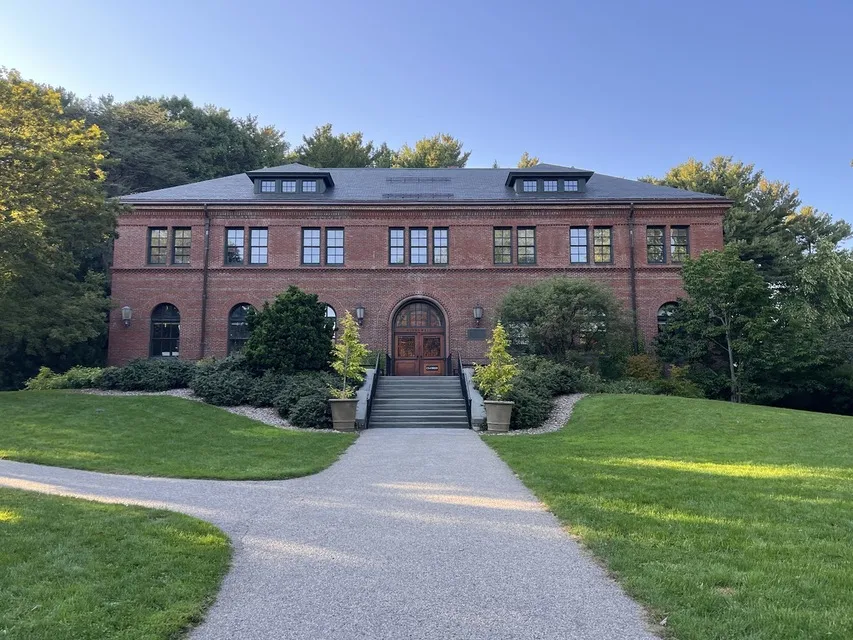 Brick visitor center and curving lawn path at the Arnold Arboretum