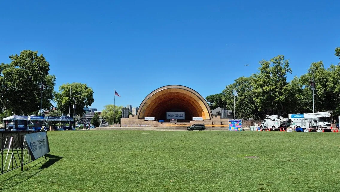 The Hatch Memorial Shell and its lawn on the Charles River Esplanade on a clear summer day