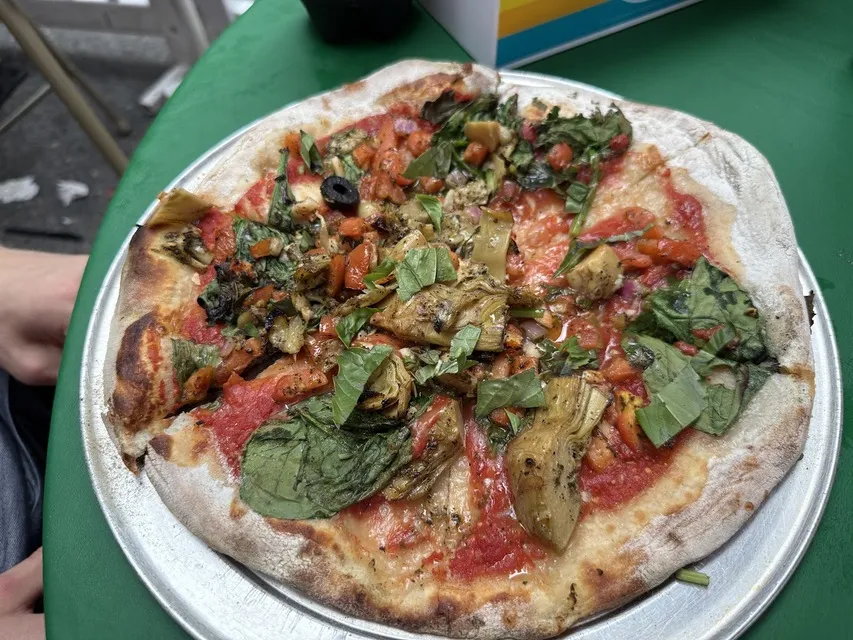 Brick-oven pizza topped with artichokes, olives and basil at Regina Pizzeria
